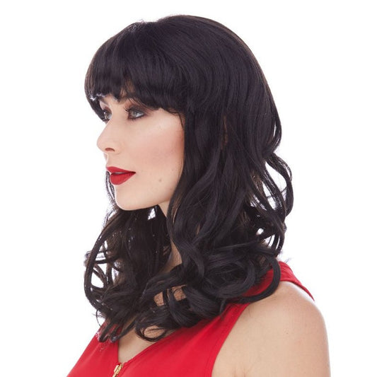 Catherine est une perruque synthétique mi-longue en noir de la marque Sepia coiffée avec une frange longue et ses longueurs ondulées.