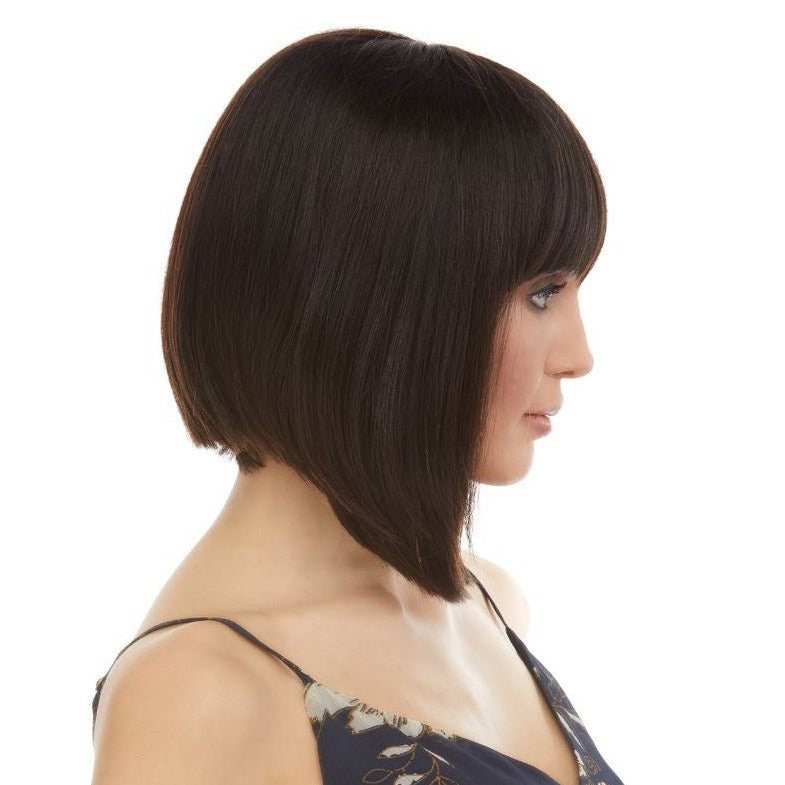 Jaylyn est une perruque mi-longue en brun et en cheveux 100% naturels de la marque Eleganté. Ses cheveux lisses sont coupés en carré plongeant et sa frange longue et graphique est coupée droite.