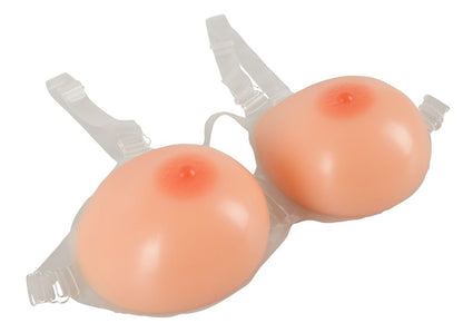 Des faux seins en silicone à bretelles pour travestis poids 2400 g de la marque Cottelli Accessories, vus de côté.