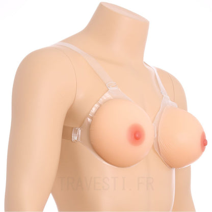 Une paire de faux seins en silicone à placer dans le soutien-gorge de forme ronde pour une poitrine ferme et jeune et un décolleté plongeant.